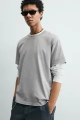 Camiseta de corte boxy fit, con cuello redondo y manga corta. Presenta un acabado irregular con efecto lavado que le otorga un aspecto vintage.