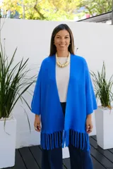 Saco abierto de punto color azul vibrante, con mangas tres cuartos y detalle de flecos largos en el ruedo.