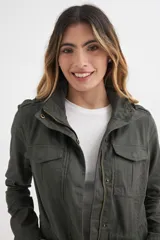 Chaqueta color verde militar de algodón, con cierre frontal con cremallera y botones a presión, cuello alto con trabilla, charreteras en los hombros, cuatro bolsillos frontales con solapa y cordón ajustable en la cintura.