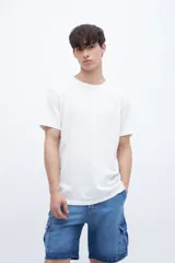 Remera de manga corta color blanco, con cuello redondo y corte holgado.