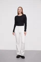 Pantalon jean de tiro alto con corte flare y terminación desflecada en el ruedo. Presenta un diseño clásico de cinco bolsillos con costuras en contraste.