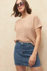 Minifalda de jean azul de tiro medio, con costuras decorativas en forma de 'V' en la parte delantera.