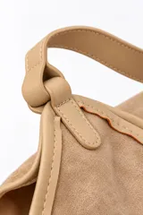 Bolso tipo hobo confeccionado en gamuza y PU, en color beige, con asa superior fija.
