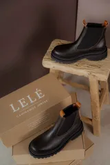 Botas tipo Chelsea de cuero color marrón con paneles elásticos laterales negros y suela track de goma negra con plataforma.
