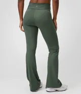 Pantalón flare deportivo Get Over de color verde oscuro, confeccionado en microfibra con cintura alta, pretina ancha, calce ajustado y vivos frontales.