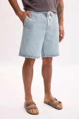 Bermuda de jean en azul medio con lavado suave, bolsillos clásicos y corte por encima de la rodilla.