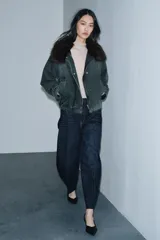 Jeans de tiro alto con corte barrel y diseño tapered, confeccionados en denim con efecto lavado y detalle de raya planchada. Presentan cintura con trabillas, cierre frontal con cremallera y botón, y bolsillos funcionales en delantero y espalda.