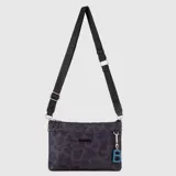 Cartera tipo bandolera de tamaño pequeño en color marrón, confeccionada en poliéster y nylon. Presenta cierre superior, correa ajustable con logo de la marca estampado y un dije colgante con la letra B en color verde lima.