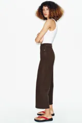 Jeans de tiro alto con diseño wide leg y corte cropped. Presenta cinco bolsillos, cierre frontal con cremallera y botón metálico.