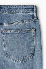 Jean de cinco bolsillos en denim de algodón con lavado medio y efecto desgastado. Modelo de cintura clásica con cierre y botón metálico, pierna recta y corte estándar.