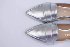 Mocasines negros de cuero con punta fina y detalle de antifaz.