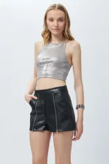 Short negro de cuero sintético con bolsillos laterales y cierres metálicos decorativos en el frente.