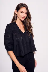 Blusa negra de algodón peinado con calce oversize, escote en V, mangas tres cuartos abullonadas y detalles de encaje y bordados en el frente y mangas.