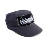 Gorra de estilo militar color gris oscuro, con un parche rectangular negro cosido a mano con hilo blanco que presenta un diseño gráfico tipo death metal.