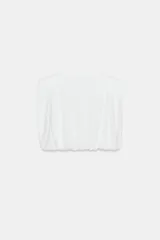 Top de algodón con cuello redondo, diseño sin mangas con hombreras marcadas y detalle de pliegues. Presenta un bajo acabado tipo globo con elástico.