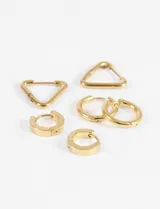 Set de tres pares de aros tipo argolla en acero quirúrgico dorado, con diseños circulares de distintos tamaños y triangulares.