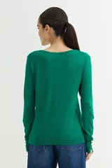 Cárdigan gris claro de viscosa y poliamida, con escote en V y cierre frontal con botones dorados.