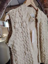 Chaleco tejido a mano en lana merino natural color crema, con cuello alto y diseño calado.