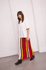 Falda larga tejida a rayas verticales en tonos azul, blanco, negro y bordó, con cintura elástica.