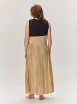 Vestido largo sin mangas de corte recto, con diseño en bloques de color horizontal que combina gris claro en la parte superior, una franja marrón en el centro y una falda mostaza con efecto desgastado.
