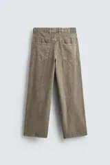 Pantalón de corte baggy fit confeccionado en tejido de algodón con textura y efecto lavado. Presenta diseño de cinco bolsillos, cierre frontal con cremallera y botón.