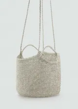 Bolso tipo shopper de tamaño pequeño, confeccionado en tejido trenzado con acabado metalizado color platino. Cuenta con doble asa corta integrada y una correa larga para llevar al hombro.