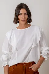 Blusa de algodón color bordó, con diseño de volados en los hombros, mangas largas con puños elásticos y corte holgado.
