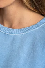 Buzo lila oversize confeccionado en 100% algodón, con cuello redondo, mangas largas y puños y dobladillo acanalados. Presenta un pequeño detalle bordado en el bajo.