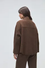 Chaqueta de lana hervida color marrón, con cuello tejido tipo polo, mangas largas y bolsillos frontales aplicados. Presenta un diseño estructurado y minimalista.