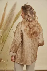 Campera tipo kimono acolchada en color azul petróleo, con diseño de costuras verticales y bolsillos frontales amplios. Presenta mangas largas con puños vueltos y un corte holgado y abierto.