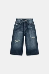 Bermuda de jean tiro medio, corte baggy y diseño holgado con detalle de rotos y cinco bolsillos.