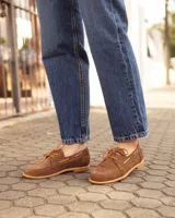 Mocasines estilo náutico de cuero color marrón, con cordones y costuras pespunteadas en el empeine.
