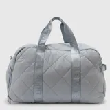 Bolso deportivo tipo duffle color negro, con diseño acolchado de rombos. Cuenta con correas de mano y correa de hombro ajustable, ambas con el logo de la marca y coordenadas estampadas.