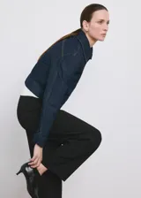 Pantalón de vestir negro de tiro medio y corte recto, con detalle de pinzas y bolsillos laterales.