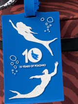 Bolso térmico cuadrado de gran capacidad, color negro con estampado en blanco de sirenas y motivos marinos. Posee asas de mano y una correa ajustable estampada con el monograma de la marca.