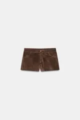 Shorts mini de tiro medio confeccionados en tejido con efecto ante. Presentan trabillas en la cintura, bolsillos delanteros y cierre frontal con cremallera y botón.
