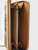 Billetera de cuero con detalles en pelo vacuno con estampado animal print, cierre perimetral y parche de cuero con logo grabado en el centro.