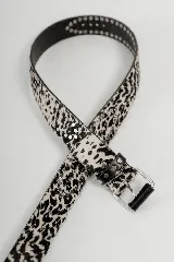 Cinturón de cuero color camel con múltiples tachas metálicas redondas y cuadradas, y hebilla metálica de estilo rústico.