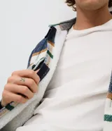 Campera de franela a cuadros con forro interno de sherpa, cuello tipo polo, cierre frontal con botones y bolsillos frontales con solapa.