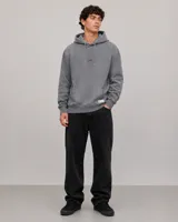 Canguro con capucha gris de corte holgado, con bolsillo frontal tipo canguro y logo pequeño estampado en el centro del pecho.
