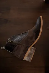 Botines de cuero color marrón oscuro con paneles laterales de gamuza negra, puntera con textura y tacón bajo.