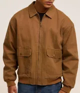 Campera bomber marrón de sarga de algodón, con cuello inglés, cierre frontal con cremallera, bolsillos cargo con botón y puños y cintura ajustados.