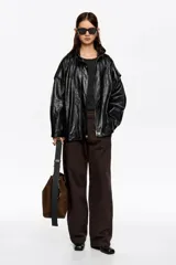 Cazadora de corte oversize confeccionada en piel, con cremallera metálica frontal oculta, cuello subido y manga larga con forma. Cuenta con bolsillos tipo alforja.