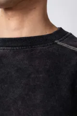 Buzo de frisa 100% algodón, color negro con lavado gastado tipo "snow". Presenta un calce oversize, cuello redondo, puños y cintura de ribb. Se caracteriza por sus costuras a contratono visibles en toda la prenda y recortes con bordado.