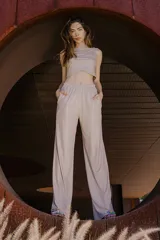 Pantalón de vestir color beige, de corte palazzo y tiro alto, con bolsillos laterales y cintura elástica.