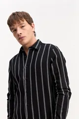 Camisa de manga larga color beige, de tejido texturado con cierre frontal de botones y cuello camisero clásico.