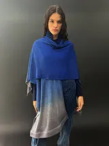 Ruana larga de lana merino color gris con cuello plisado de fieltro. Diseño degradado con terminación en flecos.