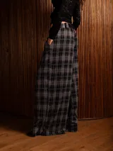 Pantalón tipo palazzo de corte amplio y tiro alto, con diseño de estampado a cuadros tipo tartán en tonos oscuros. Presenta pinzas en la cintura y bolsillos laterales.