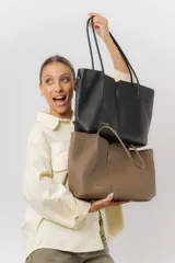 Cartera tipo tote de diseño amplio y estructurado, confeccionada en material sintético con textura graneada. Cuenta con doble asa larga para llevar al hombro y un interior espacioso.