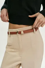 Pantalón tobillero de tiro medio, color azul marino, con bolsillos delanteros y cierre frontal con cremallera, botón y gancho. Incluye un cinturón fino de color marrón con hebilla metálica.